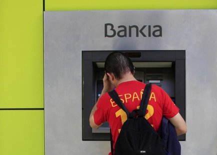 A man uses an ATM machine at a Bankia bank branch in the Andalusian capital of Seville, southern Spain October 28, 2013. REUTERS/Marcelo del A man uses an ATM machine at a Bankia bank branch in the Andalusian capital of Seville, southern Spain October 28, 2013. REUTERS/Marcelo del
