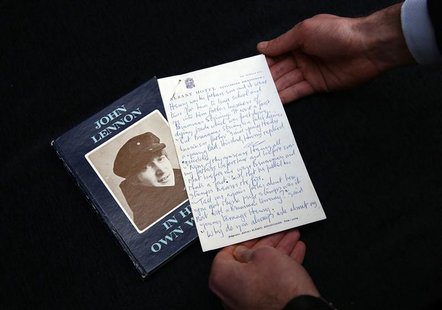 A manuscript written by John Lennon entitled 'Henry and Harry' is held for the cameras by a Sotheby's employee, London March 21, 2014. REUTE A manuscript written by John Lennon entitled 'Henry and Harry' is held for the cameras by a Sotheby's employee, London March 21, 2014. REUTE