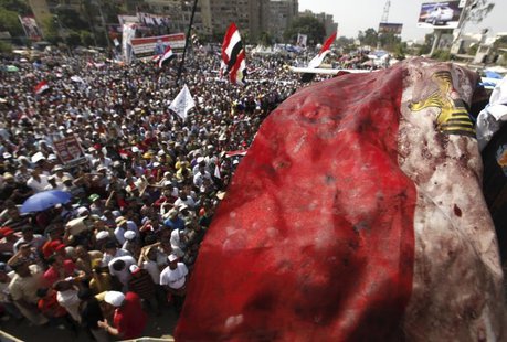 An Egyptian flag stained with blood flutters over members of the Muslim Brotherhood and supporters of deposed Egyptian President Mohamed Mur An Egyptian flag stained with blood flutters over members of the Muslim Brotherhood and supporters of deposed Egyptian President Mohamed Mur