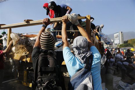 Anti-government protesters unload debris from a truck to build a barricade along a highway during a protest against Nicolas Maduro's governm Anti-government protesters unload debris from a truck to build a barricade along a highway during a protest against Nicolas Maduro's governm