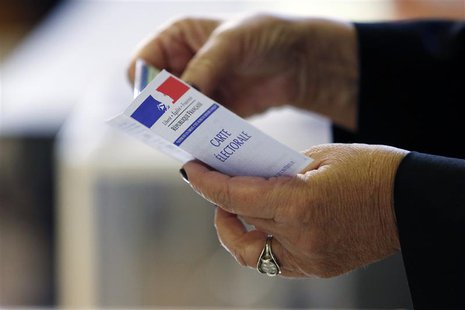 A woman holds an electoral card at a polling station in Paris March 23, 2014. REUTERS/Gonzalo Fuentes A woman holds an electoral card at a polling station in Paris March 23, 2014. REUTERS/Gonzalo Fuentes