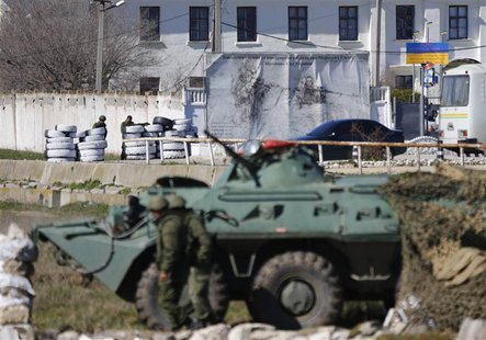 Armed men, believed to be Russian servicemen, stand guard in front of a Ukrainian marine base in the Crimean port city of Feodosia March 23, Armed men, believed to be Russian servicemen, stand guard in front of a Ukrainian marine base in the Crimean port city of Feodosia March 23,