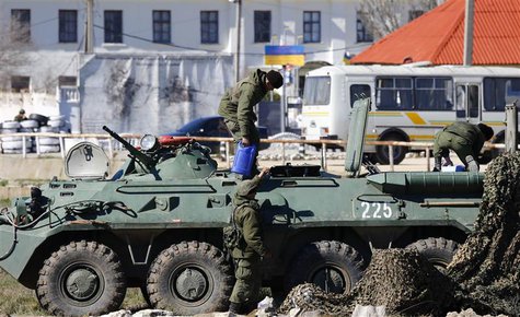 Armed men, believed to be Russian servicemen, supply an armoured personnel carrier (APC) in front of a Ukrainian marine base in the Crimean Armed men, believed to be Russian servicemen, supply an armoured personnel carrier (APC) in front of a Ukrainian marine base in the Crimean