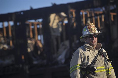 A firefighter stands in front of the charred remains of the Mariner's Cove Inn in Point Pleasant Beach, New Jersey, March 21, 2014. REUTERS/ A firefighter stands in front of the charred remains of the Mariner's Cove Inn in Point Pleasant Beach, New Jersey, March 21, 2014. REUTERS/