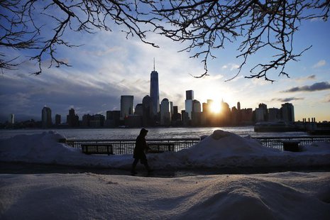 The New York skyline and the One World Trade Center are seen in the distance as a man makes his commute after a night of snow from New York The New York skyline and the One World Trade Center are seen in the distance as a man makes his commute after a night of snow from New York