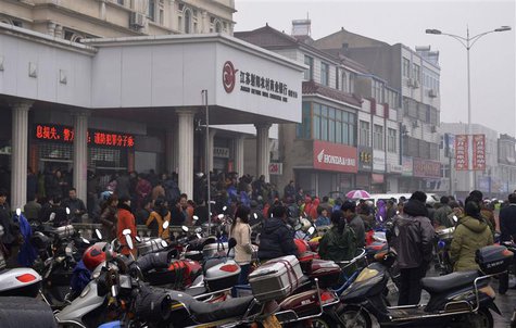 People gather in front of a branch of Jiangsu Sheyang Rural Commercial Bank, in Yancheng, Jiangsu province, March 25, 2014. REUTERS/Stringer People gather in front of a branch of Jiangsu Sheyang Rural Commercial Bank, in Yancheng, Jiangsu province, March 25, 2014. REUTERS/Stringer