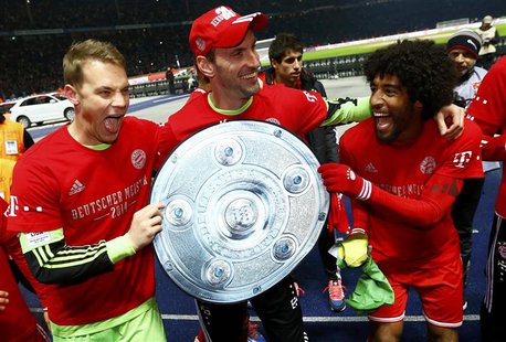 Bayern Munich's goalkeepers Manuel Neuer and Tom Starke (C) hold a mock German soccer championship trophy with Dante (R) as they celebrate w Bayern Munich's goalkeepers Manuel Neuer and Tom Starke (C) hold a mock German soccer championship trophy with Dante (R) as they celebrate w