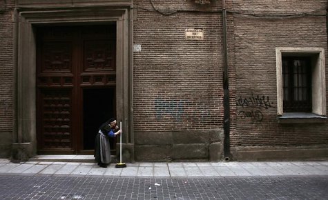 An old nun brushes garbage strewn on the pavement from the entrance of her convent during the fourth day of an indefinite strike by street c An old nun brushes garbage strewn on the pavement from the entrance of her convent during the fourth day of an indefinite strike by street c