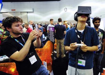 Software designer Julian Kantor (L), who created ''The Recital'' takes a picture of Jonathan Feng (R) as he uses the Oculus Rift virtual reality headset to experience his program during E3 in Los Angeles, California June 12, 2013.
CREDIT: REUTERS/GUS RUELAS Software designer Julian Kantor (L), who created ''The Recital'' takes a picture of Jonathan Feng (R) as he uses the Oculus Rift virtual reality headset to experience his program during E3 in Los Angeles, California June 12, 2013.
CREDIT: REUTERS/GUS RUELAS