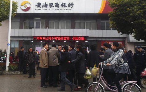 People gather in front of a branch of Rural Commercial Bank of Huanghai in Yancheng, Jiangsu province, March 26, 2014. REUTERS/Carlos Barria People gather in front of a branch of Rural Commercial Bank of Huanghai in Yancheng, Jiangsu province, March 26, 2014. REUTERS/Carlos Barria