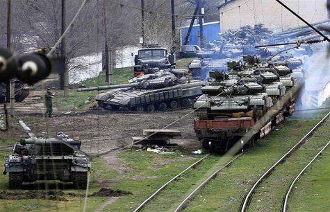 A Russian soldier (L) guides a Ukrainian tank, which is to be loaded onto a train, in northern Crimea March 27, 2014. REUTERS/Yannis Behraki A Russian soldier (L) guides a Ukrainian tank, which is to be loaded onto a train, in northern Crimea March 27, 2014. REUTERS/Yannis Behraki