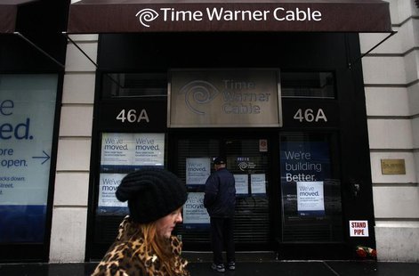 A woman walks past the old Time Warner Cable headquarters as a man tries to enter the building in New York February 13, 2014. REUTERS/Joshua A woman walks past the old Time Warner Cable headquarters as a man tries to enter the building in New York February 13, 2014. REUTERS/Joshua