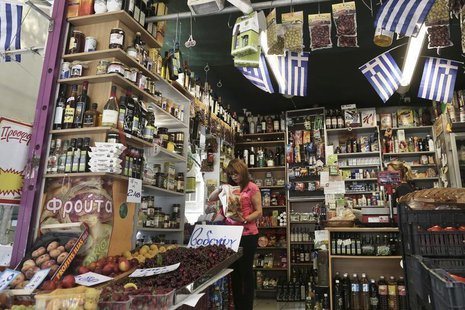A woman buys products in a grocery market in Athens July 2, 2013. REUTERS/John Kolesidis A woman buys products in a grocery market in Athens July 2, 2013. REUTERS/John Kolesidis