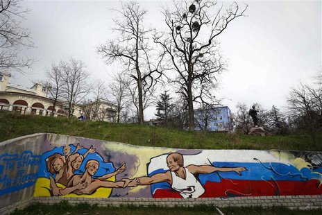 Graffiti depicting Russian President Vladimir Putin (R) extending a hand to the Ukrainian people is seen on a wall in the Crimean city of Si Graffiti depicting Russian President Vladimir Putin (R) extending a hand to the Ukrainian people is seen on a wall in the Crimean city of Si