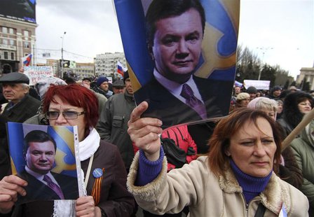Pro-Russian activists hold pictures of ousted Ukrainian President Victor Yanukovich during a protest in central Donetsk March 29, 2014. Russ Pro-Russian activists hold pictures of ousted Ukrainian President Victor Yanukovich during a protest in central Donetsk March 29, 2014. Russ