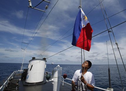 A Philippine Navy crew member aboard a civilian supply ship raises a Philippine national flag after the ship was able to evade an attempted A Philippine Navy crew member aboard a civilian supply ship raises a Philippine national flag after the ship was able to evade an attempted
