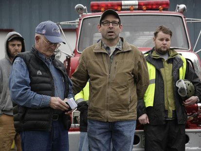 Darrington Mayor Dan Rankin (2nd R) and Pastor Mike De Luca (2nd L) lead workers and community members in prayer and a moment of silence mar Darrington Mayor Dan Rankin (2nd R) and Pastor Mike De Luca (2nd L) lead workers and community members in prayer and a moment of silence mar