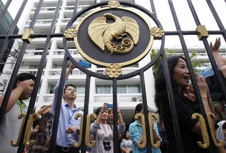 Thailand's Finance Ministry officers stand behind the ministry's gate while anti-government protesters rally outside in central Bangkok Apri Thailand's Finance Ministry officers stand behind the ministry's gate while anti-government protesters rally outside in central Bangkok Apri