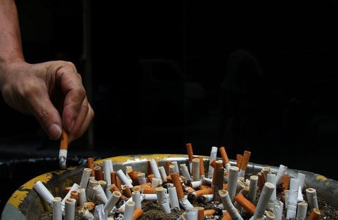 A man discards a cigarette butt outside a construction site in Central, a business district in Hong Kong, October 18, 2006. REUTERS/Paul Yeu A man discards a cigarette butt outside a construction site in Central, a business district in Hong Kong, October 18, 2006. REUTERS/Paul Yeu