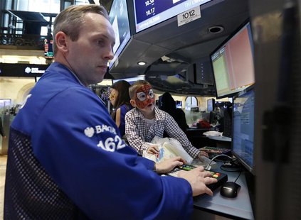 A trader monitors trades as a young boy watches on the floor of the New York Stock Exchange, November 23, 2012. REUTERS/Brendan McDermid A trader monitors trades as a young boy watches on the floor of the New York Stock Exchange, November 23, 2012. REUTERS/Brendan McDermid