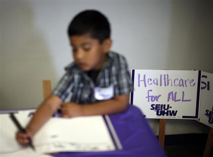 A boy draws signs at a health insurance enrolment event in Commerce, California March 31, 2014. REUTERS/Lucy Nicholson A boy draws signs at a health insurance enrolment event in Commerce, California March 31, 2014. REUTERS/Lucy Nicholson