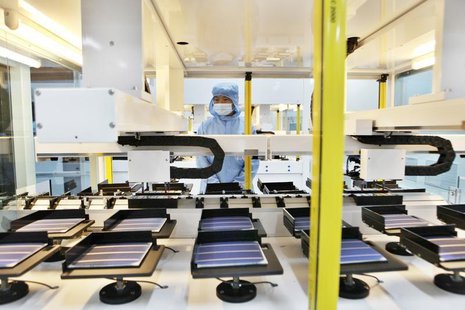 An employee works along a solar panel production line at a factory of Shanghai Chaori Solar Energy Science and Technology Co Ltd, in Jiujian An employee works along a solar panel production line at a factory of Shanghai Chaori Solar Energy Science and Technology Co Ltd, in Jiujian