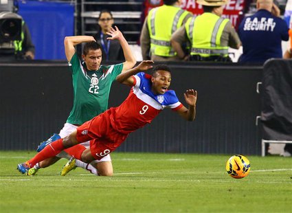 Apr 2, 2014; Glendale, AZ, USA; USA forward Julian Green (9) falls as he collides with Mexico defender Paul Aguilar (22) in the second half Apr 2, 2014; Glendale, AZ, USA; USA forward Julian Green (9) falls as he collides with Mexico defender Paul Aguilar (22) in the second half
