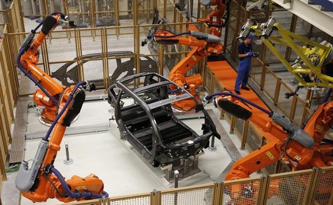 A worker makes technical measurements with robots on the carbon chassis at the serial production BMW i3 electric car in the BMW factory in L A worker makes technical measurements with robots on the carbon chassis at the serial production BMW i3 electric car in the BMW factory in L