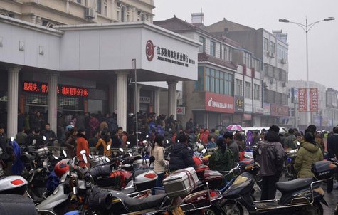 People gather in front of a branch of Jiangsu Sheyang Rural Commercial Bank, in Yancheng, Jiangsu province, March 25, 2014. REUTERS/Stringer People gather in front of a branch of Jiangsu Sheyang Rural Commercial Bank, in Yancheng, Jiangsu province, March 25, 2014. REUTERS/Stringer