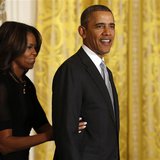 U.S. President Barack Obama is helped offstage by first lady Michelle Obama after an event held to honor members of the U.S. teams and deleg U.S. President Barack Obama is helped offstage by first lady Michelle Obama after an event held to honor members of the U.S. teams and deleg