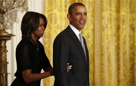 U.S. President Barack Obama is helped offstage by first lady Michelle Obama after an event held to honor members of the U.S. teams and deleg U.S. President Barack Obama is helped offstage by first lady Michelle Obama after an event held to honor members of the U.S. teams and deleg