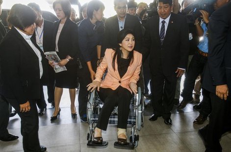 Thailand's Prime Minister Yingluck Shinawatra (C) arrives on a wheelchair at the Royal Police Cadet Academy in Nakorn Pathom province, March Thailand's Prime Minister Yingluck Shinawatra (C) arrives on a wheelchair at the Royal Police Cadet Academy in Nakorn Pathom province, March