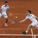 Britain's Andy Murray (R) returns a ball as his teammate Colin Fleming looks on during their Davis Cup quarter-final doubles tennis match ag Britain's Andy Murray (R) returns a ball as his teammate Colin Fleming looks on during their Davis Cup quarter-final doubles tennis match ag