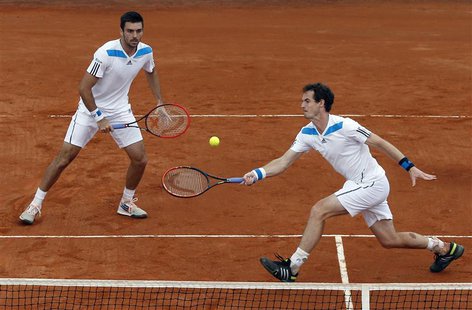 Britain's Andy Murray (R) returns a ball as his teammate Colin Fleming looks on during their Davis Cup quarter-final doubles tennis match ag Britain's Andy Murray (R) returns a ball as his teammate Colin Fleming looks on during their Davis Cup quarter-final doubles tennis match ag