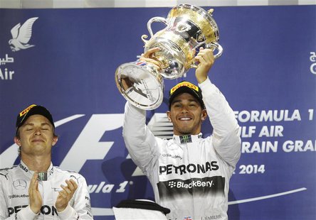 Mercedes Formula One driver Lewis Hamilton of Britain holds up his trophy next to teammate Nico Rosberg of Germany on the podium of the Bahr Mercedes Formula One driver Lewis Hamilton of Britain holds up his trophy next to teammate Nico Rosberg of Germany on the podium of the Bahr