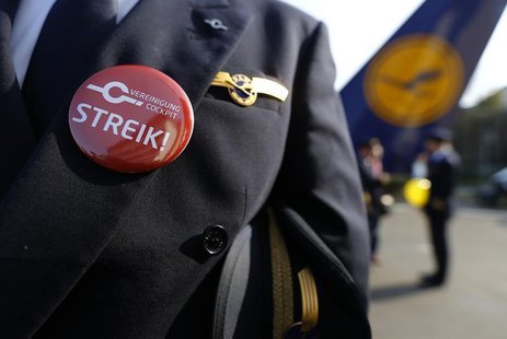 A pilot of German airline Lufthansa, sports a buttons reading "strike" on his uniform as he takes part in a demonstration at Fraport airport A pilot of German airline Lufthansa, sports a buttons reading "strike" on his uniform as he takes part in a demonstration at Fraport airport