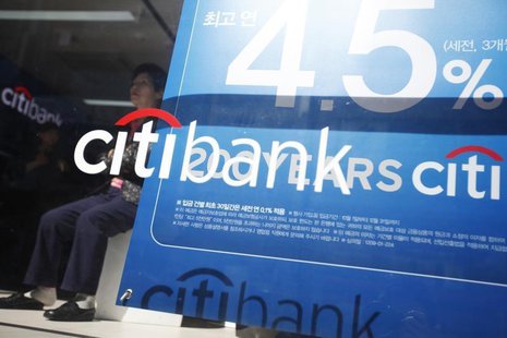 A woman sits next to an advertisement board for interest rates of savings deposits for Citibank in central Seoul October 11, 2012. REUTERS/K A woman sits next to an advertisement board for interest rates of savings deposits for Citibank in central Seoul October 11, 2012. REUTERS/K