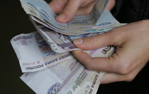 A vendor counts Russian rouble banknotes at a market in Moscow, March 3, 2014. REUTERS/Maxim Shemetov A vendor counts Russian rouble banknotes at a market in Moscow, March 3, 2014. REUTERS/Maxim Shemetov