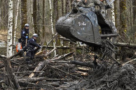 Rescuers watch carefully as an excavator combs through the large debris pile left by a mudslide in Oso, Washington, April 4, 2014. REUTERS/M Rescuers watch carefully as an excavator combs through the large debris pile left by a mudslide in Oso, Washington, April 4, 2014. REUTERS/M
