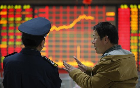 An investor (R) talks to a security guard in front of an electronic board showing stock information at a brokerage house in Huaibei, Anhui p An investor (R) talks to a security guard in front of an electronic board showing stock information at a brokerage house in Huaibei, Anhui p
