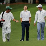 Britain's amateur Matthew Fitzpatrick (C) and Northern Ireland's Rory McIlroy (R) walk up the ninth fairway during a practice round ahead of Britain's amateur Matthew Fitzpatrick (C) and Northern Ireland's Rory McIlroy (R) walk up the ninth fairway during a practice round ahead of