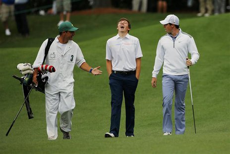 Britain's amateur Matthew Fitzpatrick (C) and Northern Ireland's Rory McIlroy (R) walk up the ninth fairway during a practice round ahead of Britain's amateur Matthew Fitzpatrick (C) and Northern Ireland's Rory McIlroy (R) walk up the ninth fairway during a practice round ahead of