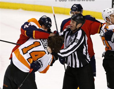 Apr 8, 2014; Sunrise, FL, USA; Linesman Pierre Racicot (65) tries to break up a fight between Florida Panthers defenseman Erik Gudbranson (4 Apr 8, 2014; Sunrise, FL, USA; Linesman Pierre Racicot (65) tries to break up a fight between Florida Panthers defenseman Erik Gudbranson (4