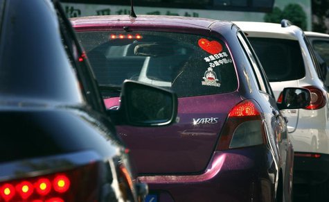 The driver of a Toyota Yaris car is reflected in a mirror as he drives along a main road in central Beijing October 9, 2012. REUTERS/David G The driver of a Toyota Yaris car is reflected in a mirror as he drives along a main road in central Beijing October 9, 2012. REUTERS/David G