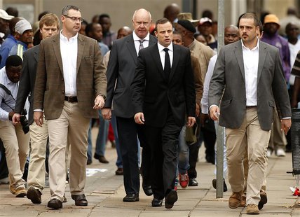 Olympic and Paralympic track star Oscar Pistorius (C) arrives ahead of his trial at the North Gauteng High Court in Pretoria April 9, 2014. Olympic and Paralympic track star Oscar Pistorius (C) arrives ahead of his trial at the North Gauteng High Court in Pretoria April 9, 2014.