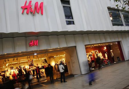 People walk past the window of an H&M textile shop in this longtime exposure photograph taken in Frankfurt December 4, 2013. REUTERS/Kai Pfa People walk past the window of an H&M textile shop in this longtime exposure photograph taken in Frankfurt December 4, 2013. REUTERS/Kai Pfa