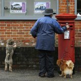 A dog walker posts a letter in a Royal Mail post box in Maybury near Woking in southern England March 25, 2014. REUTERS/Luke MacGregor A dog walker posts a letter in a Royal Mail post box in Maybury near Woking in southern England March 25, 2014. REUTERS/Luke MacGregor