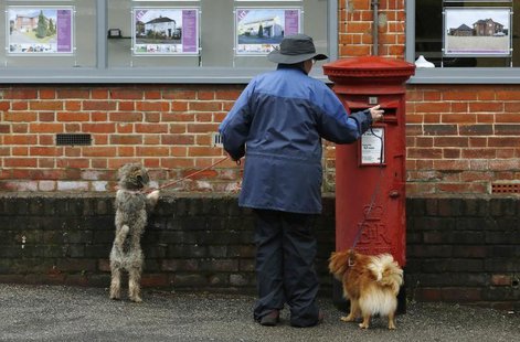 A dog walker posts a letter in a Royal Mail post box in Maybury near Woking in southern England March 25, 2014. REUTERS/Luke MacGregor A dog walker posts a letter in a Royal Mail post box in Maybury near Woking in southern England March 25, 2014. REUTERS/Luke MacGregor