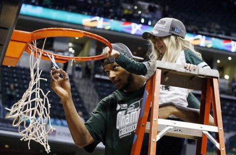 "Princess Lacey" Holsworth and Adreian Payne cutting down the nets after Michigan State won the Big Ten Championship.
(Photo : Reuters) "Princess Lacey" Holsworth and Adreian Payne cutting down the nets after Michigan State won the Big Ten Championship.
(Photo : Reuters)