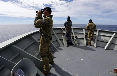 Gunner Richard Brown (L) of Transit Security Element looks through binoculars as he stands on lookout with other crew members aboard the Aus Gunner Richard Brown (L) of Transit Security Element looks through binoculars as he stands on lookout with other crew members aboard the Aus